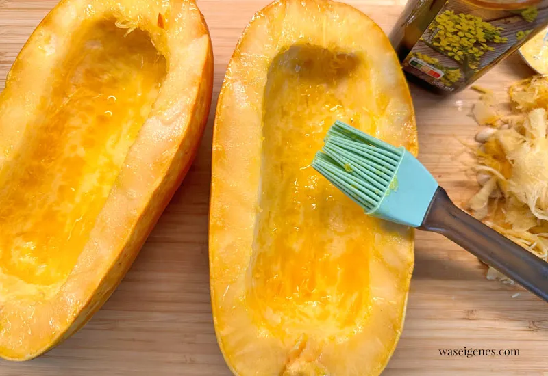 Zwei Spaghettikürbis-Hälften mit Öl bepinselt und kernentfernt, bereit für den Ofen